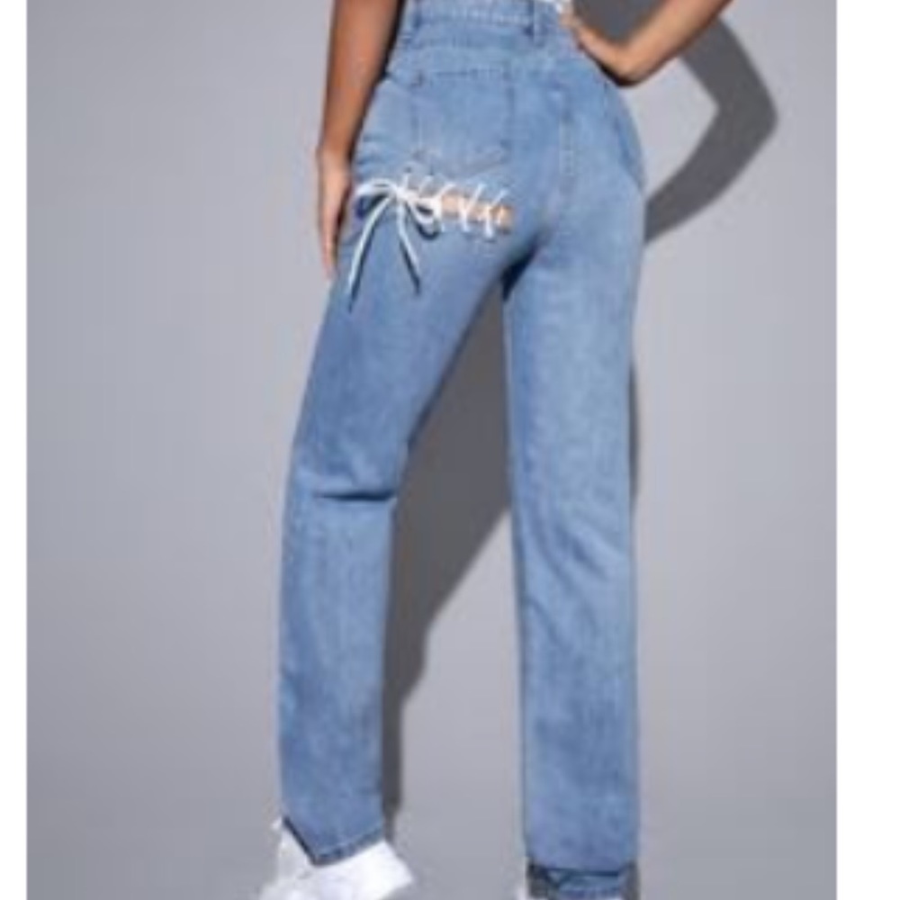 Plain boot cut jeans with a ripped and tights laced in the back of the pants